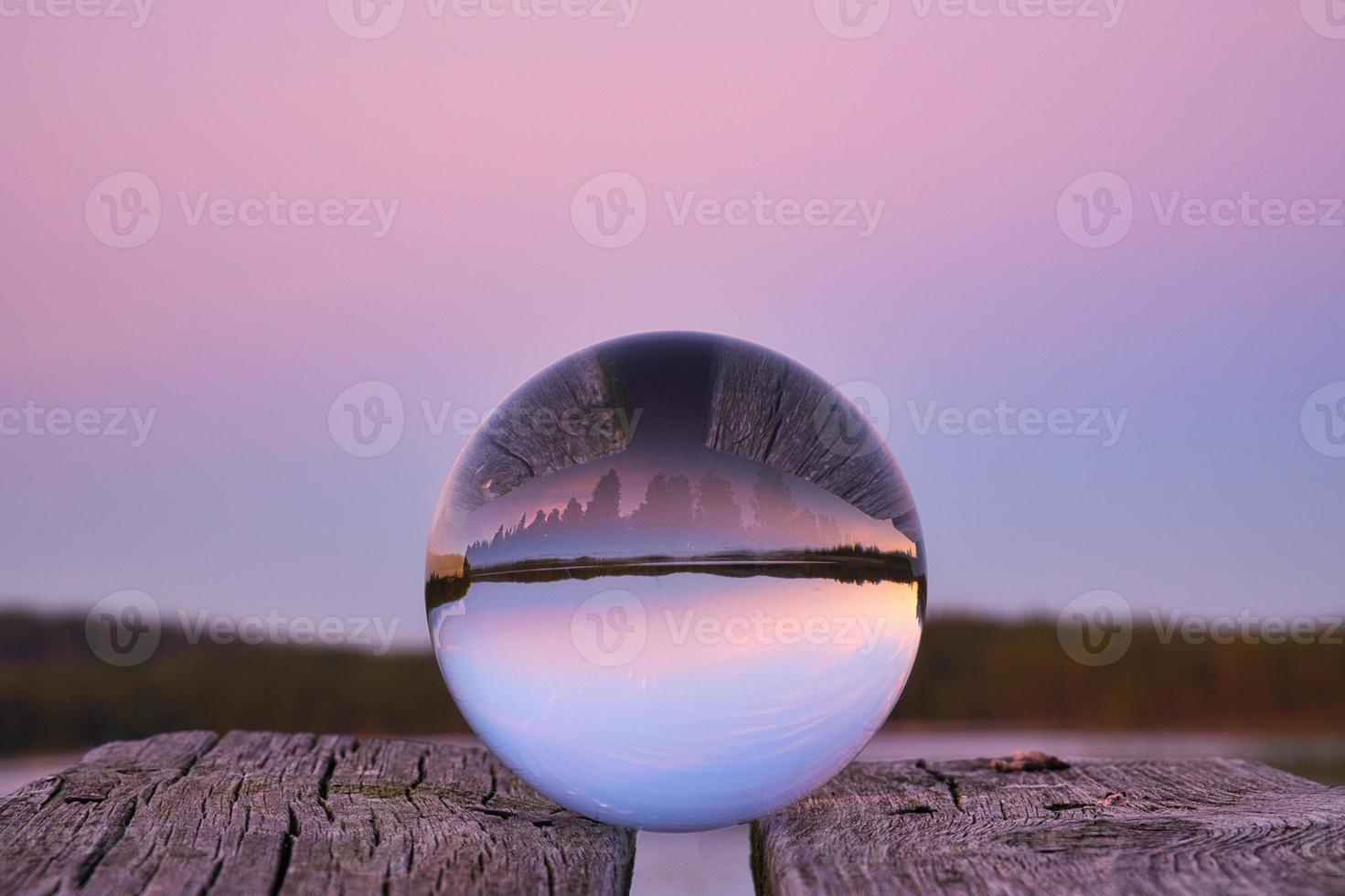 glas boll på en trä- pir på en svenska sjö på kväll timme. natur skandinavien foto