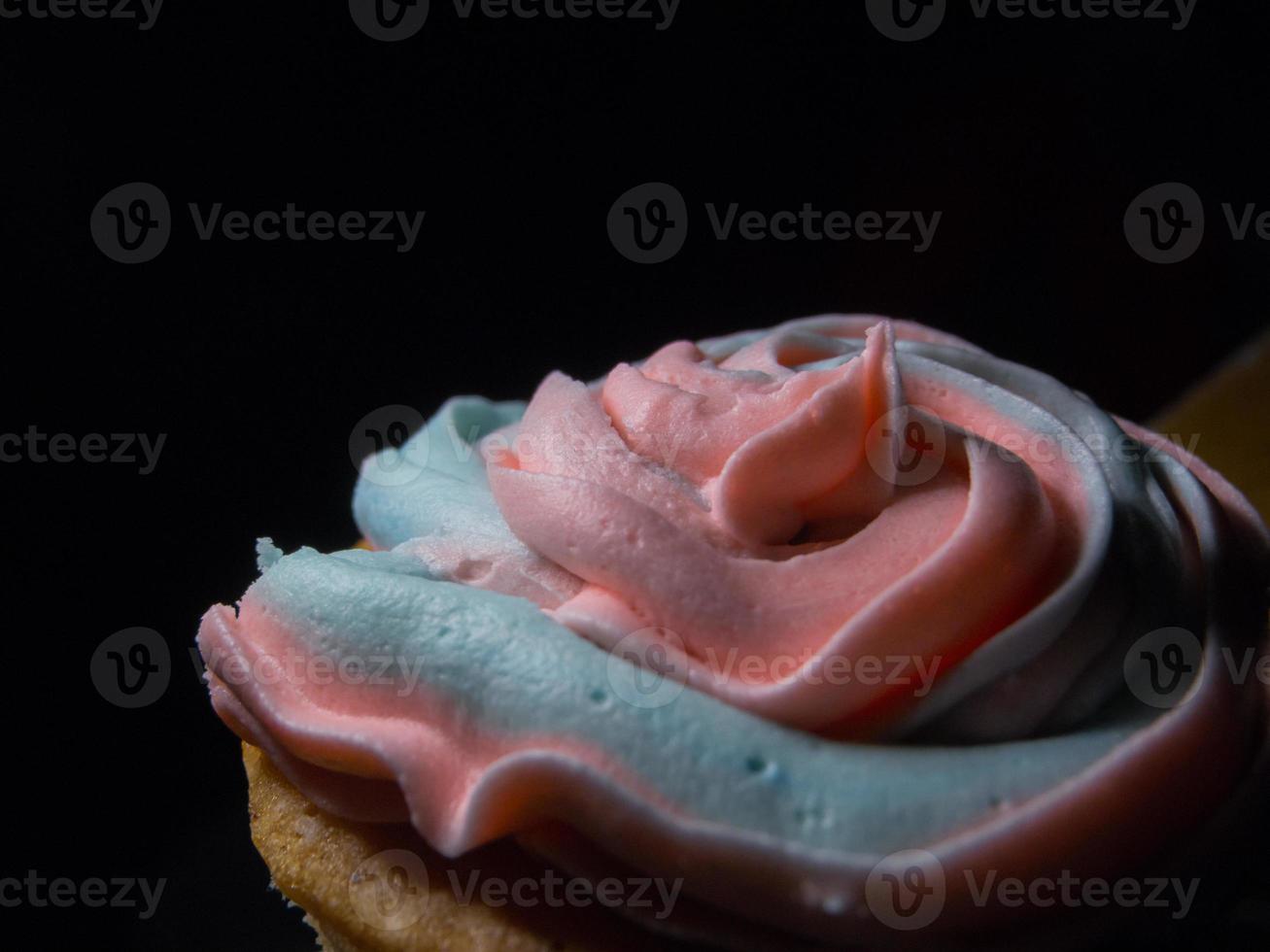 textur av en grädde av en cupcake, svart bakgrund foto