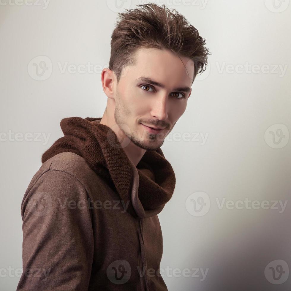 attraktiv ung man i brun tröja. foto