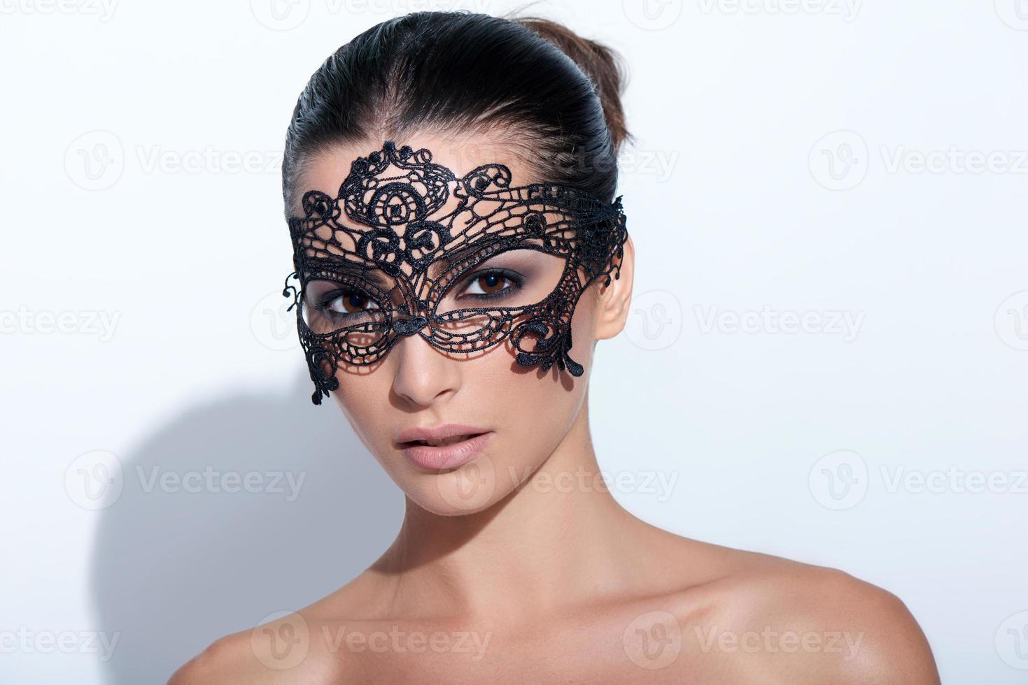 kvinna med smokey makeup på kvällen och svart spetsmask foto
