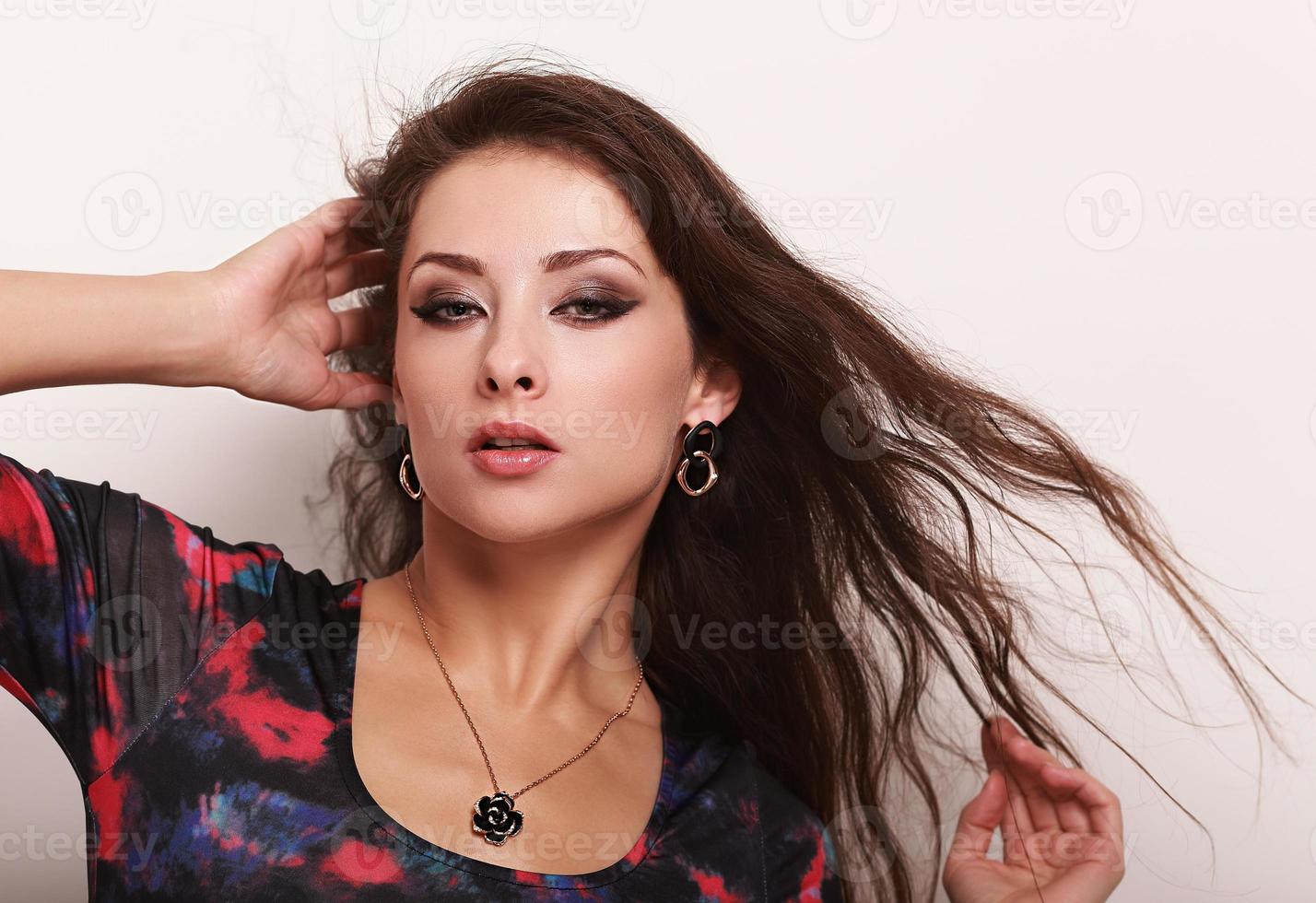vacker kvinna poserar i halsband och örhängen. närbild foto