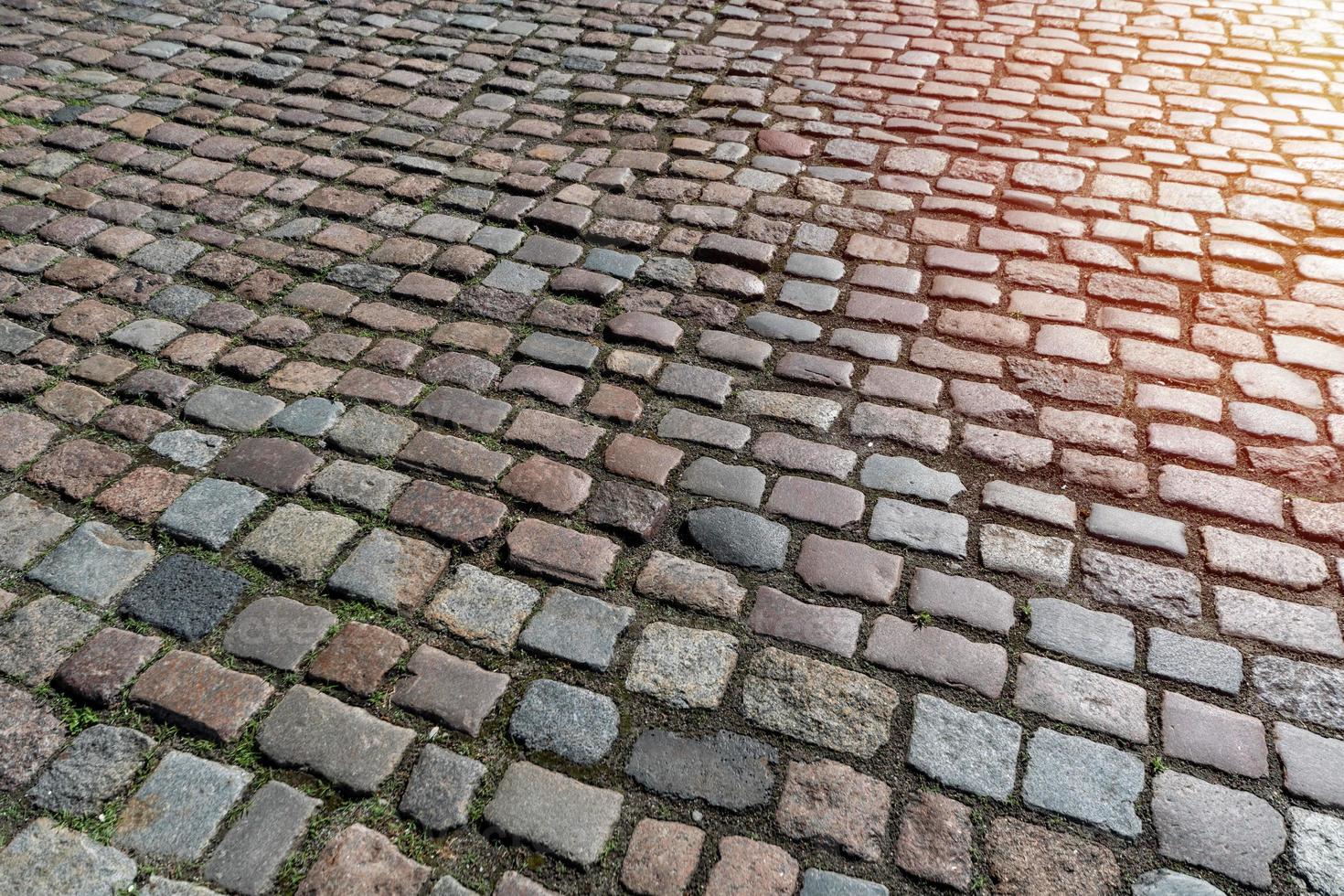 kakel textur. mönster av antiktysk kullersten i stadens centrum. små gatstenar i granit. antikgrå trottoarer. foto