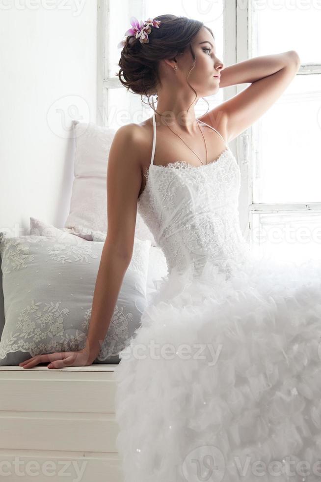 ung brud i en vit klänning foto