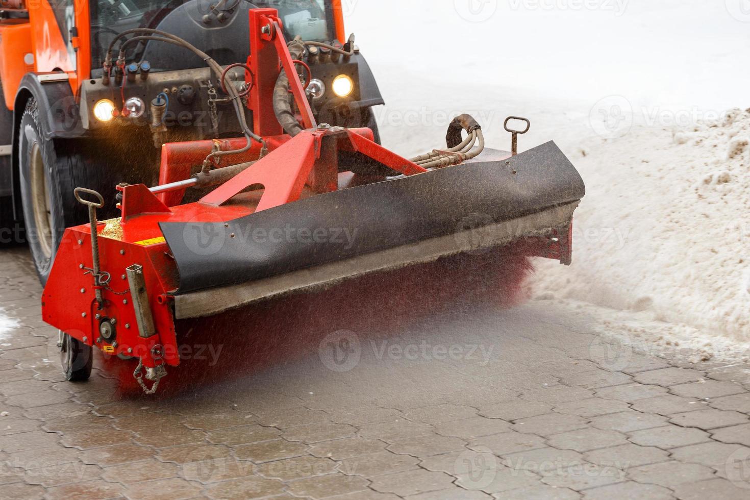 snö rengöring. snö avlägsnande traktor clearing snö från trottoar med särskild runda spinning borsta, foto