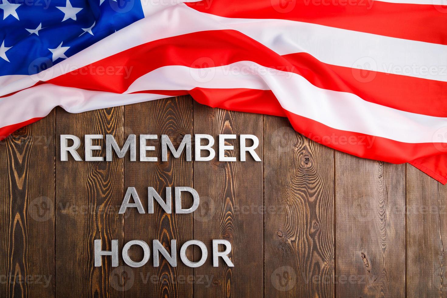 ord kom ihåg och hedra lagd med silver- metall brev på trä- bakgrund med USA flagga ovan foto