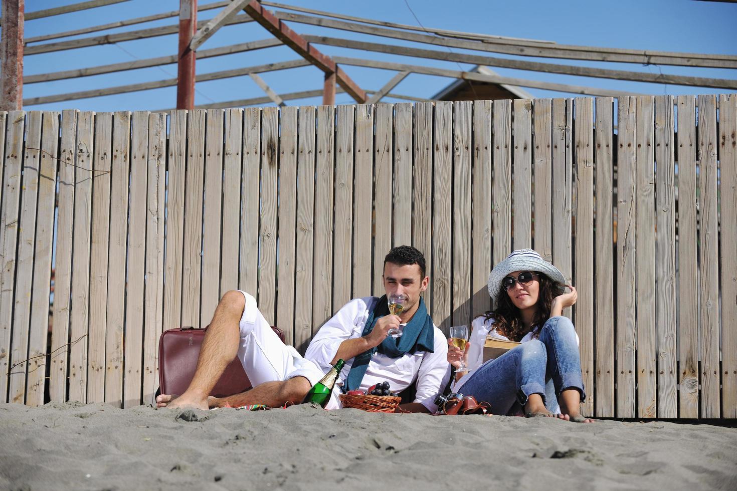 ung par njuter picknick på de strand foto