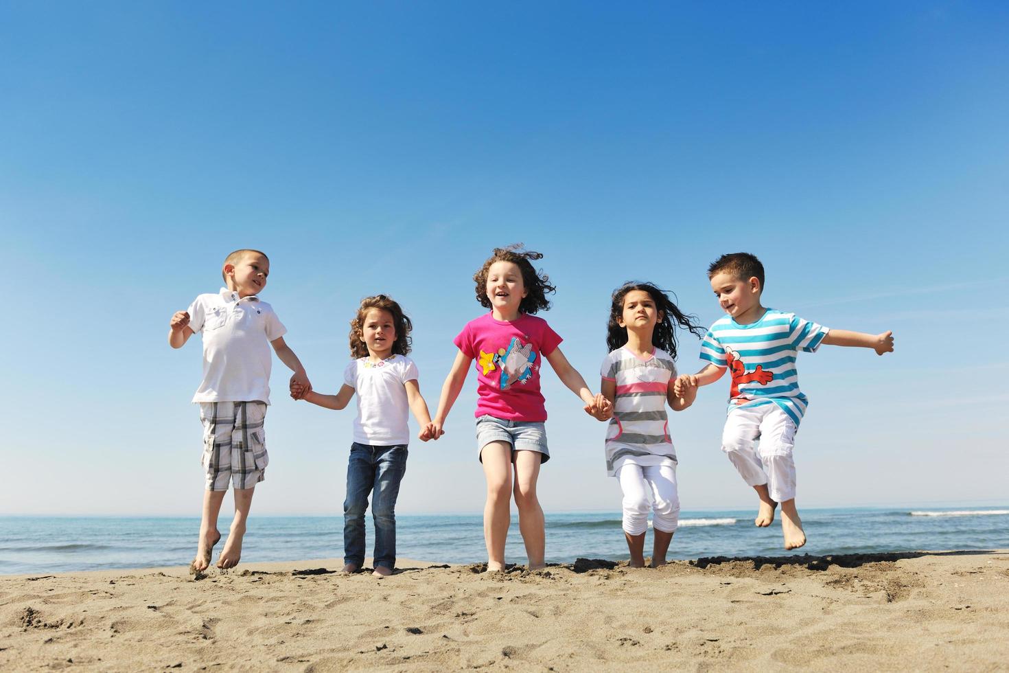 Lycklig ung människor grupp ha roligt på strand foto