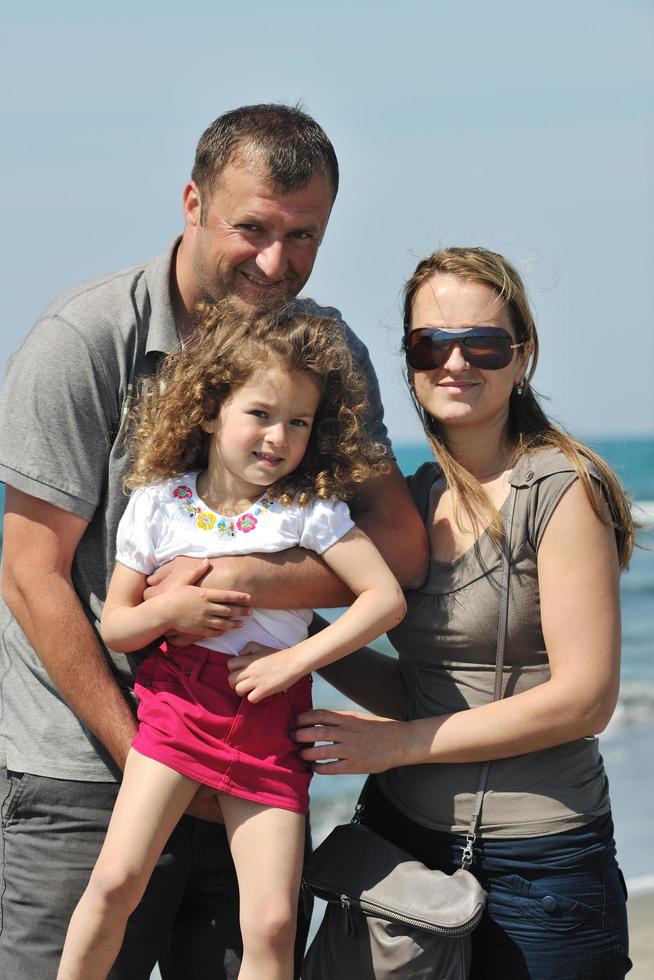 Lycklig ung familj ha roligt på strand foto