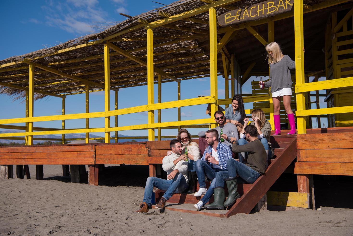 grupp av vänner har roligt på höst dag på strand foto