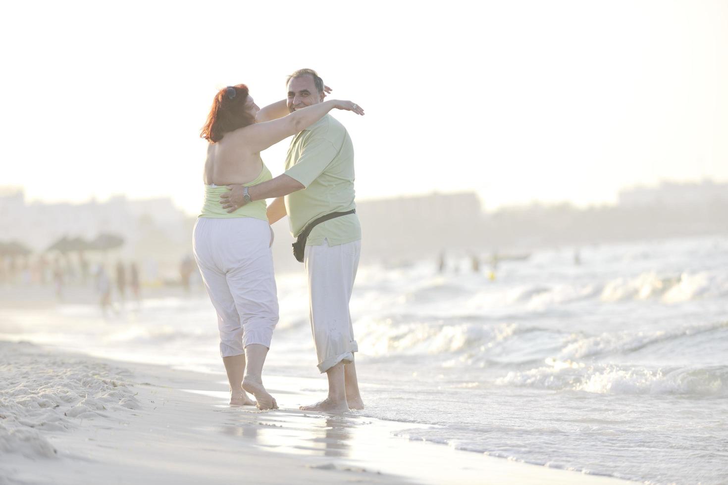 Lycklig seniors par på strand foto