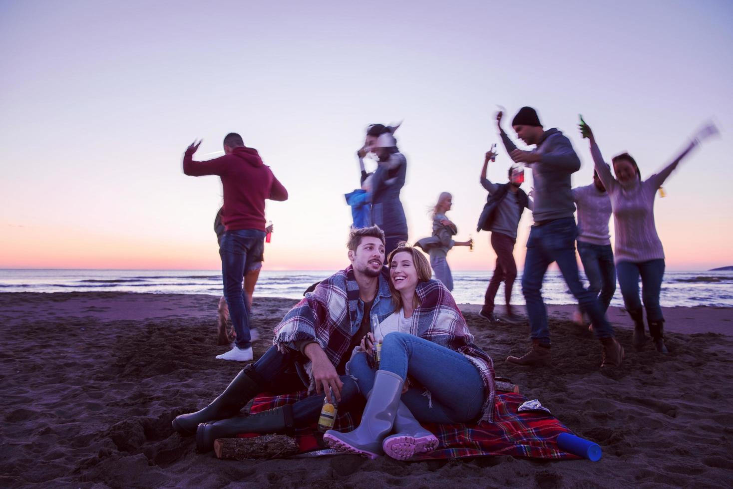 par njuter med vänner på solnedgång på de strand foto
