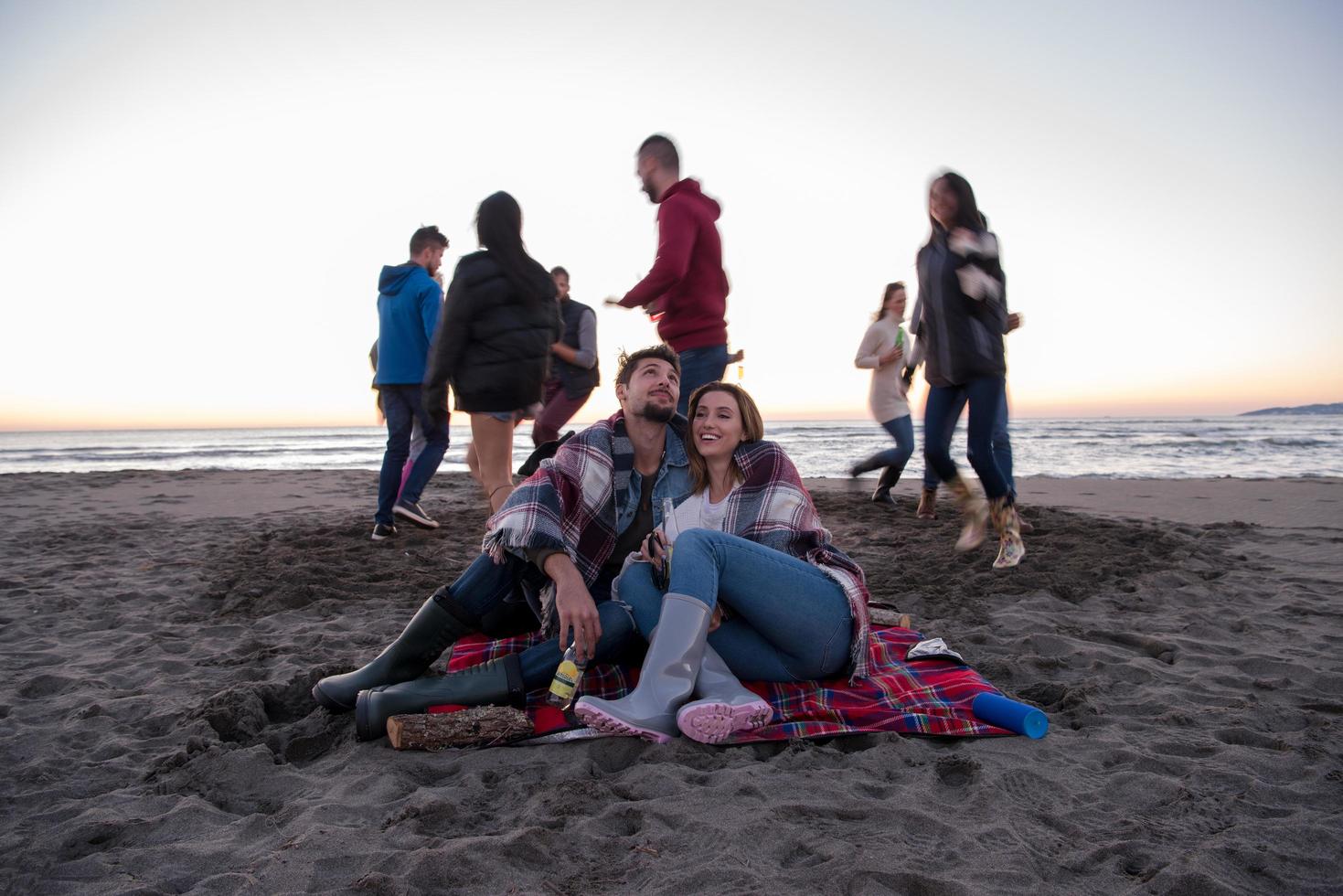 par njuter med vänner på solnedgång på de strand foto