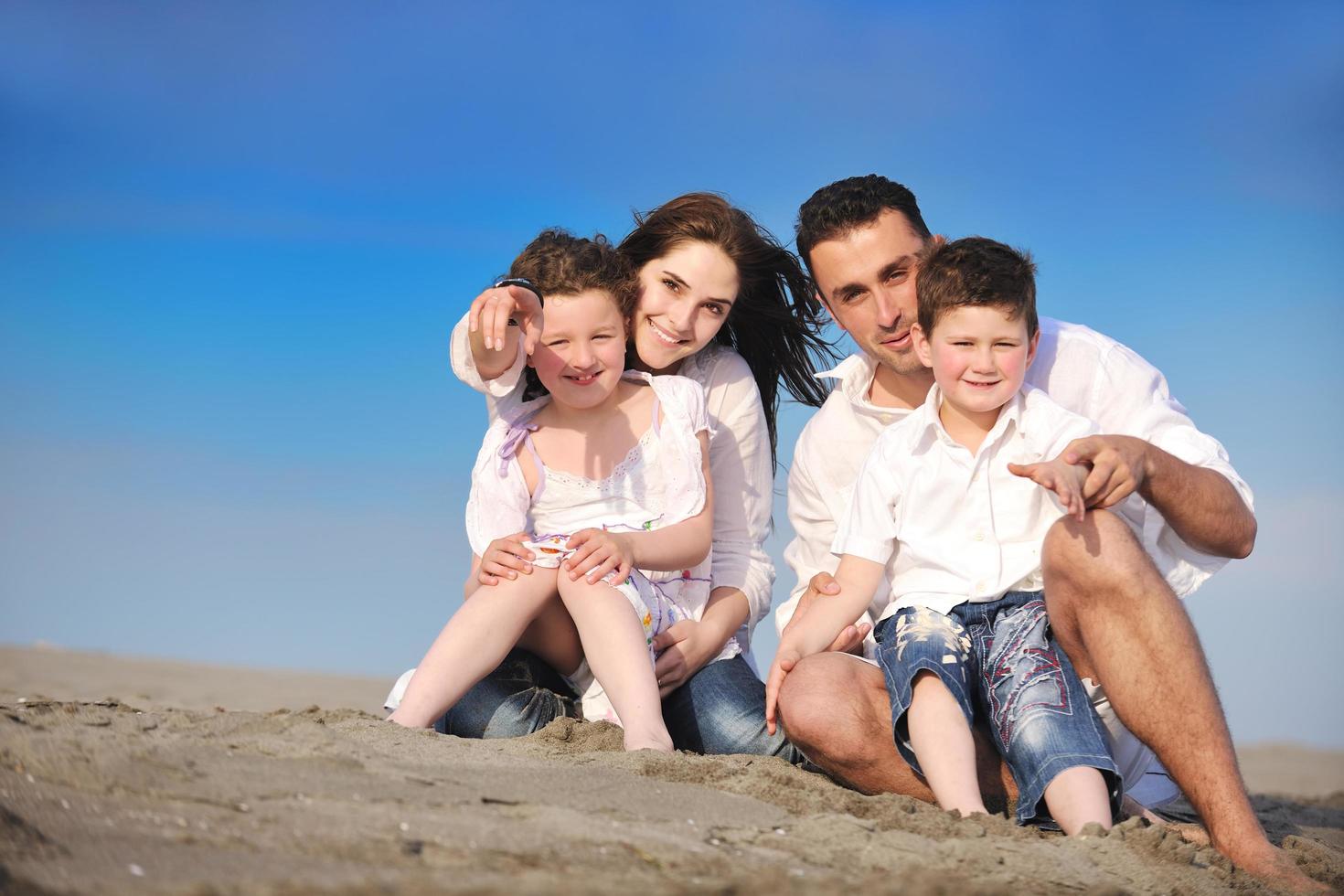 Lycklig ung familj ha roligt på strand foto