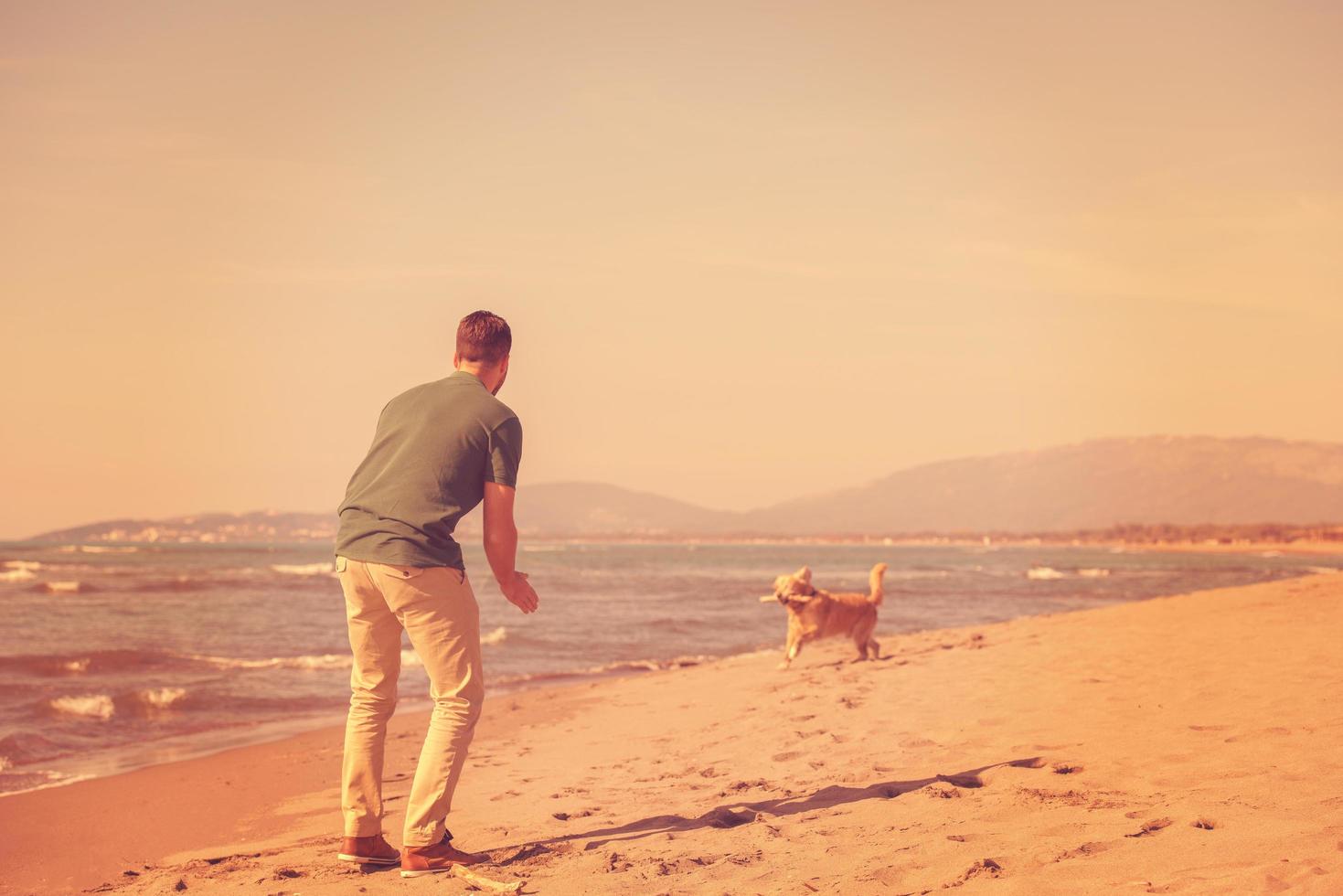 man med hund njuter fri tid på de strand foto