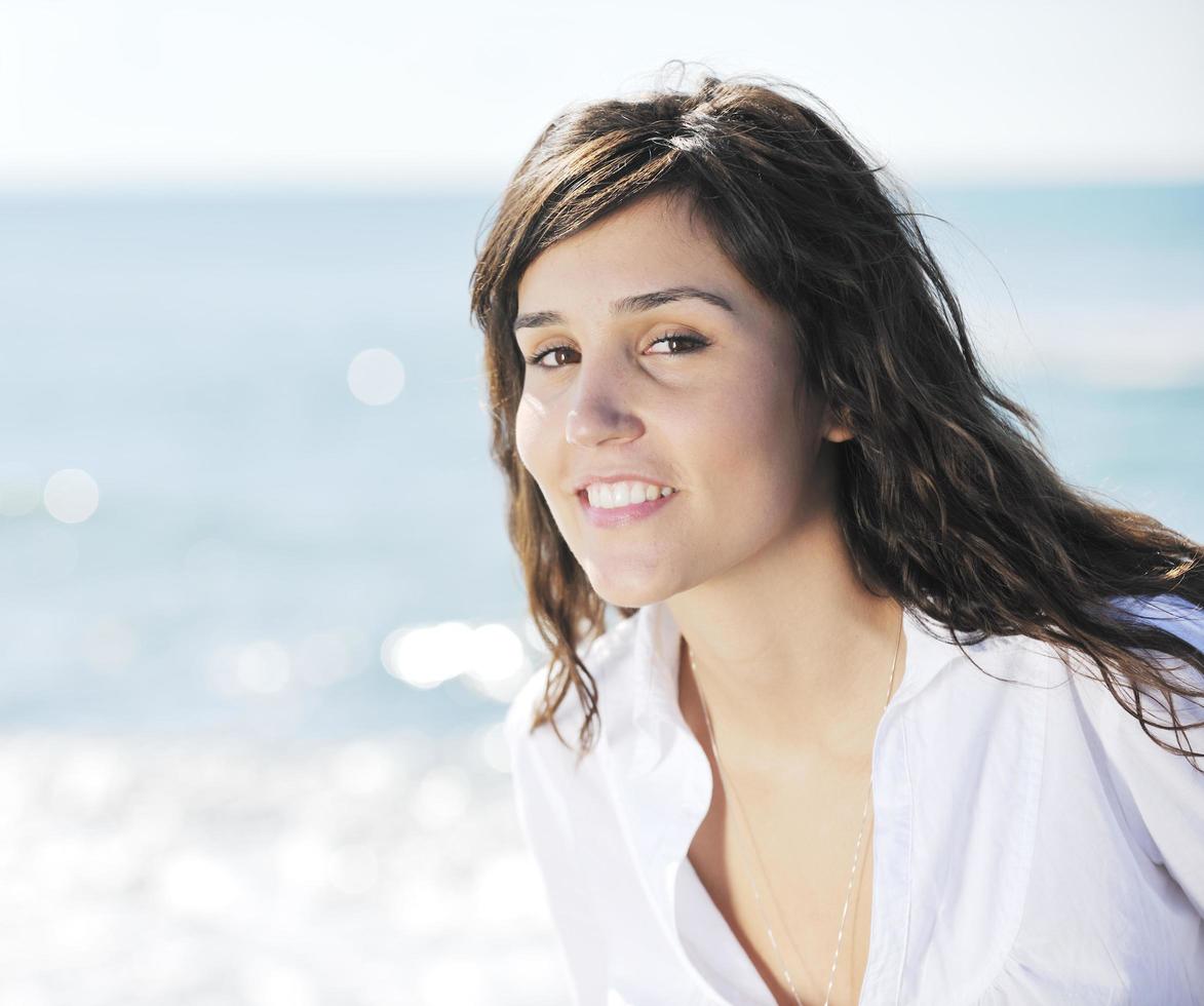 Lycklig ung kvinna på strand foto