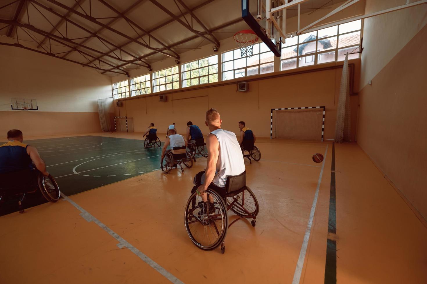 Inaktiverad krig veteraner blandad lopp och ålder basketboll lag i rullstolar spelar en Träning match i en sporter Gym hall. handikappade människor rehabilitering och inkludering begrepp foto