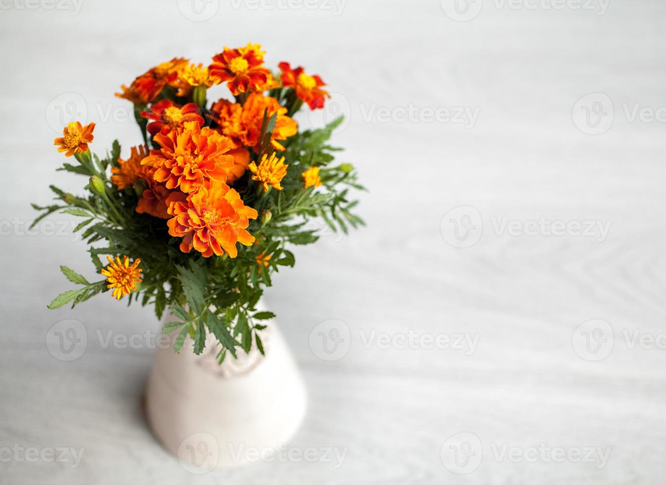 ringblommor blommor i vas på grå bakgrund foto