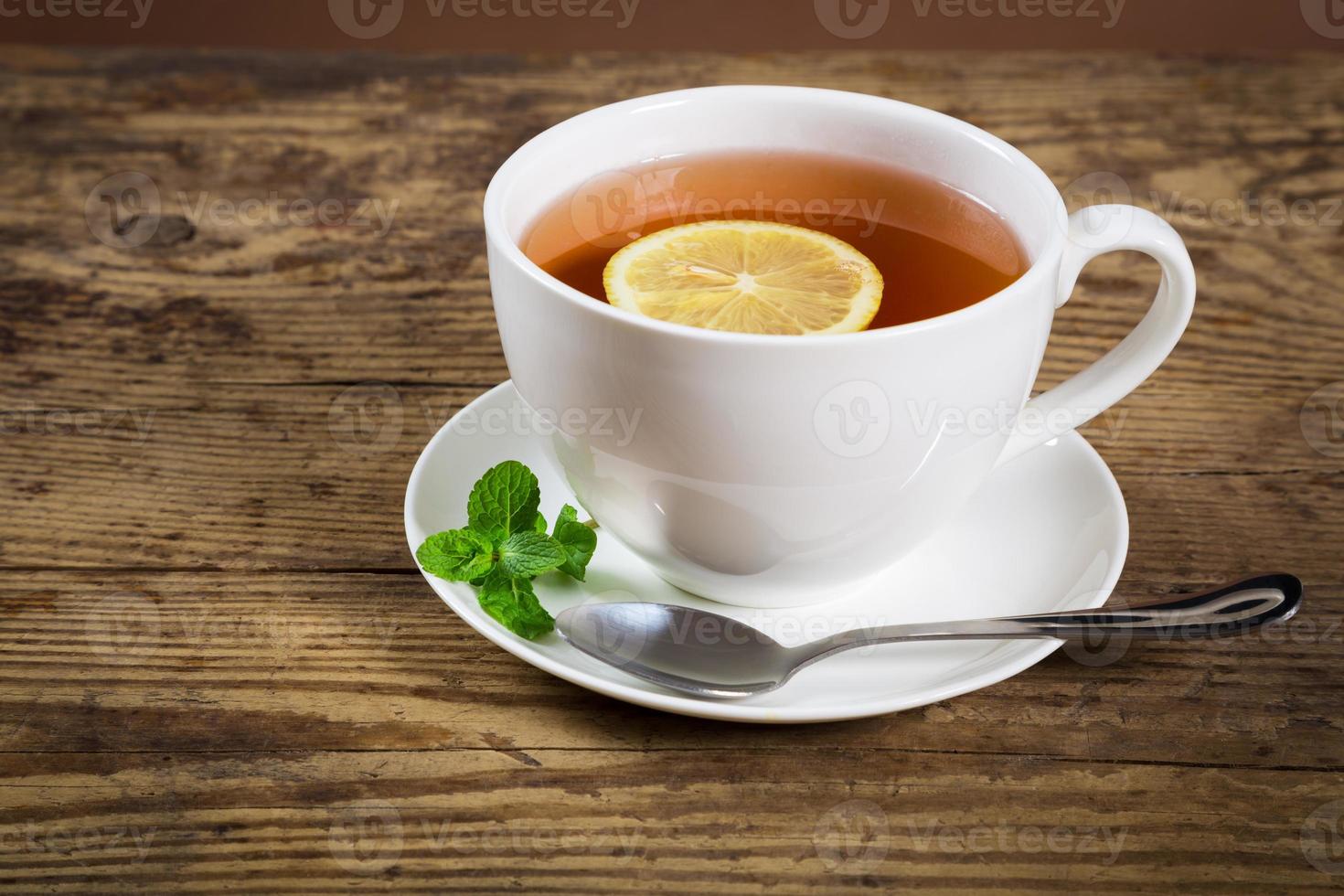 kopp te med myntablad och citron foto