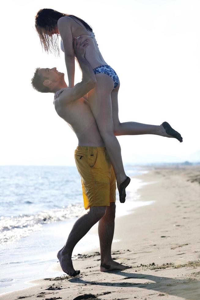 lyckliga unga par ha kul på stranden foto