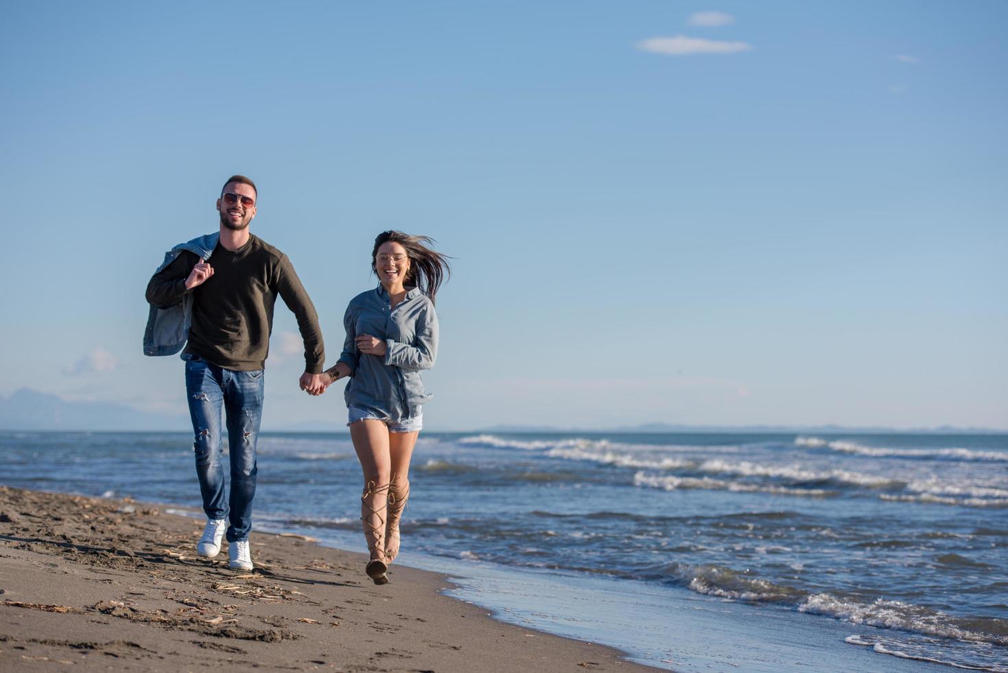 kärleksfull ung par på en strand på höst solig dag foto