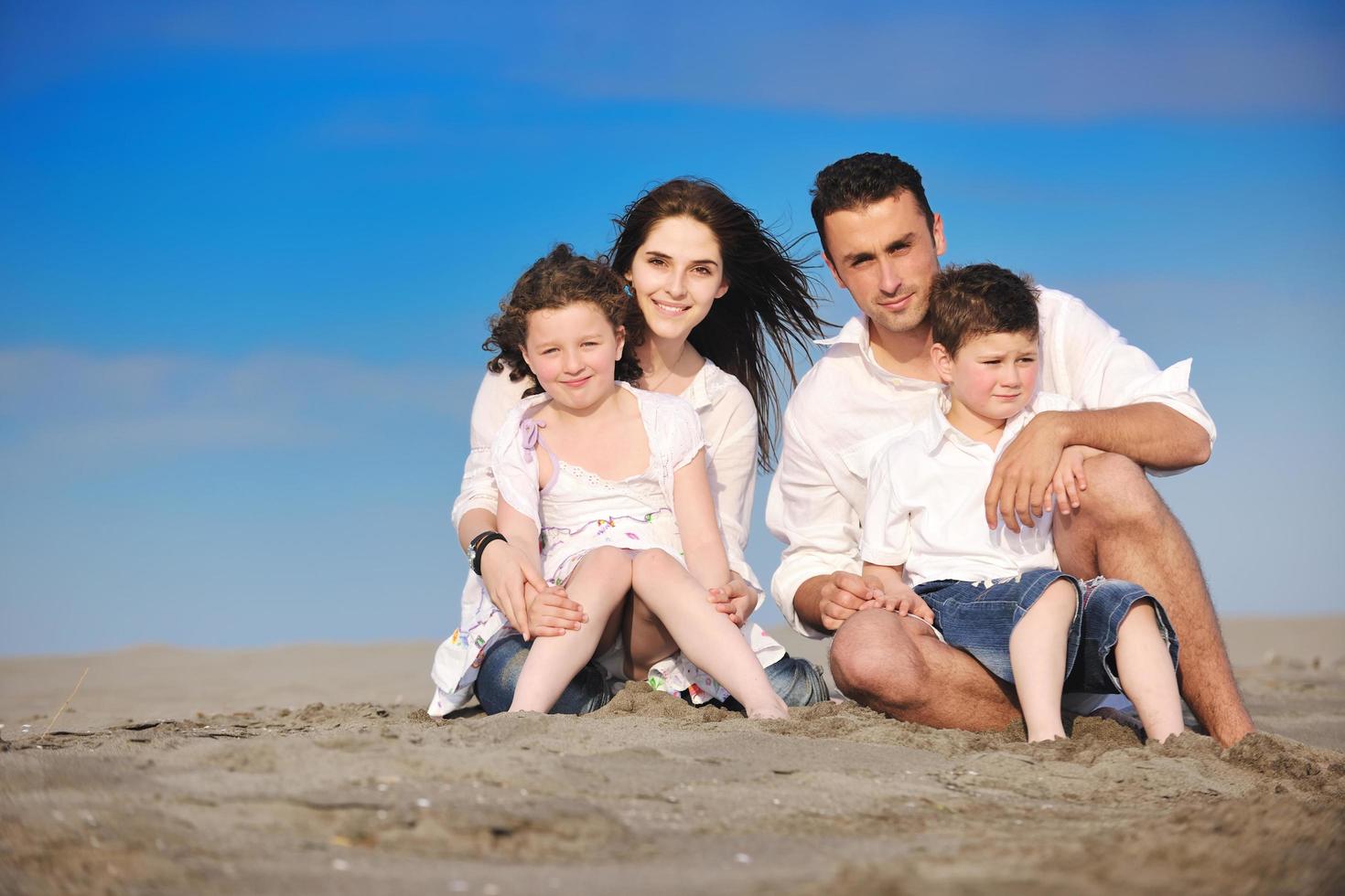 Lycklig ung familj ha roligt på strand foto