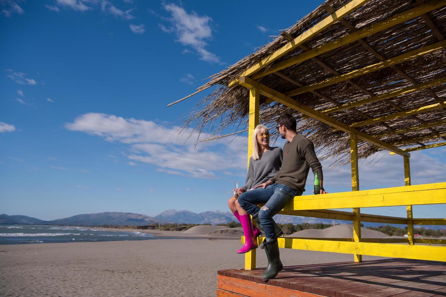 ung par dricka öl tillsammans på de strand foto