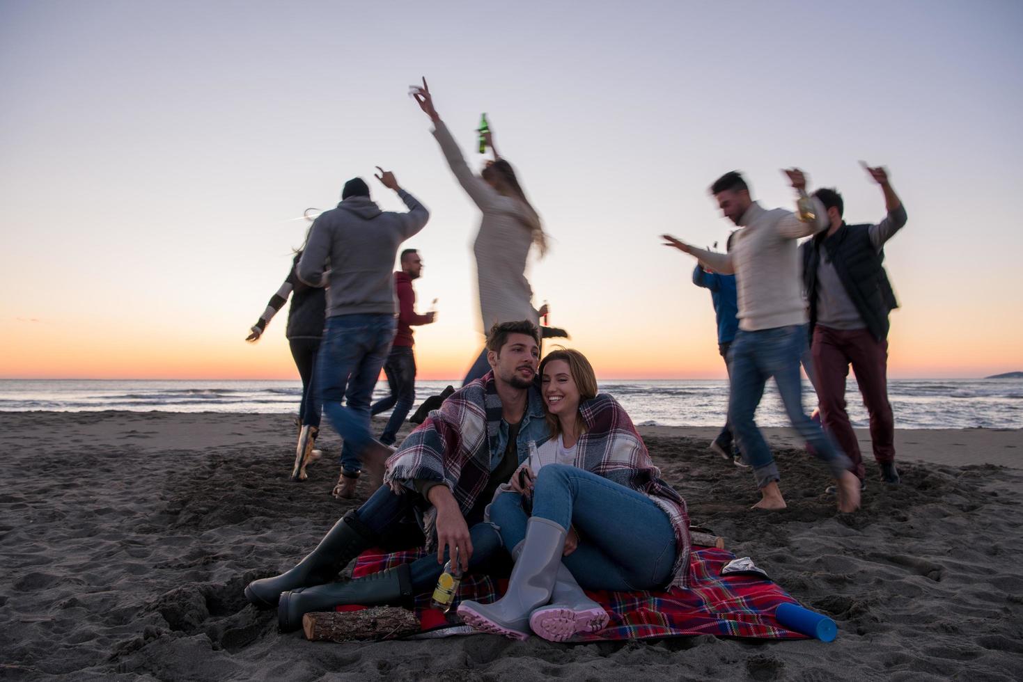 par njuter med vänner på solnedgång på de strand foto