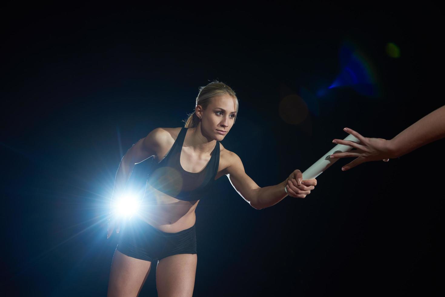 atletisk löpare godkänd batong i relä lopp foto