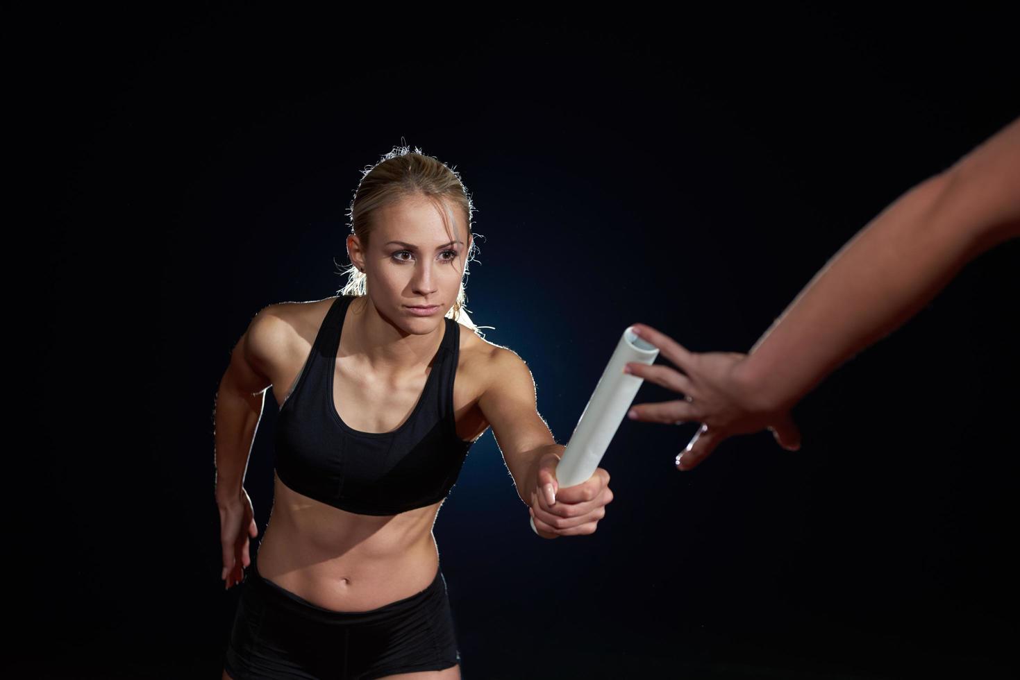 atletisk löpare godkänd batong i relä lopp foto