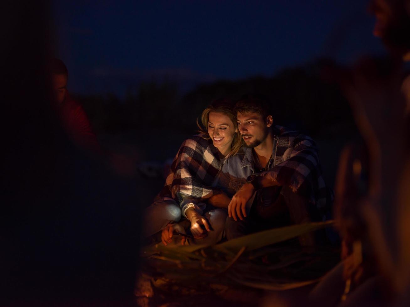 par njuter med vänner på natt på de strand foto