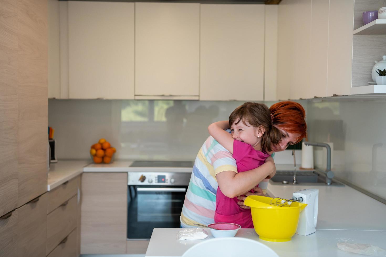 rolig liten flicka hjälpare spelar med deg på hans händer inlärning till knåda hjälper vuxen mamma i de kök, Lycklig söt bebis dotter och förälder mamma ha roligt matlagning småkakor. foto