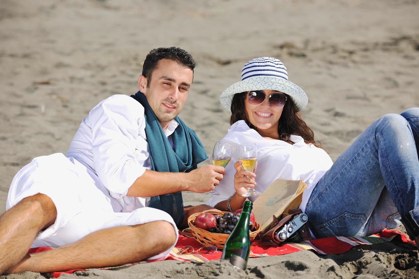 ung par njuter picknick på de strand foto
