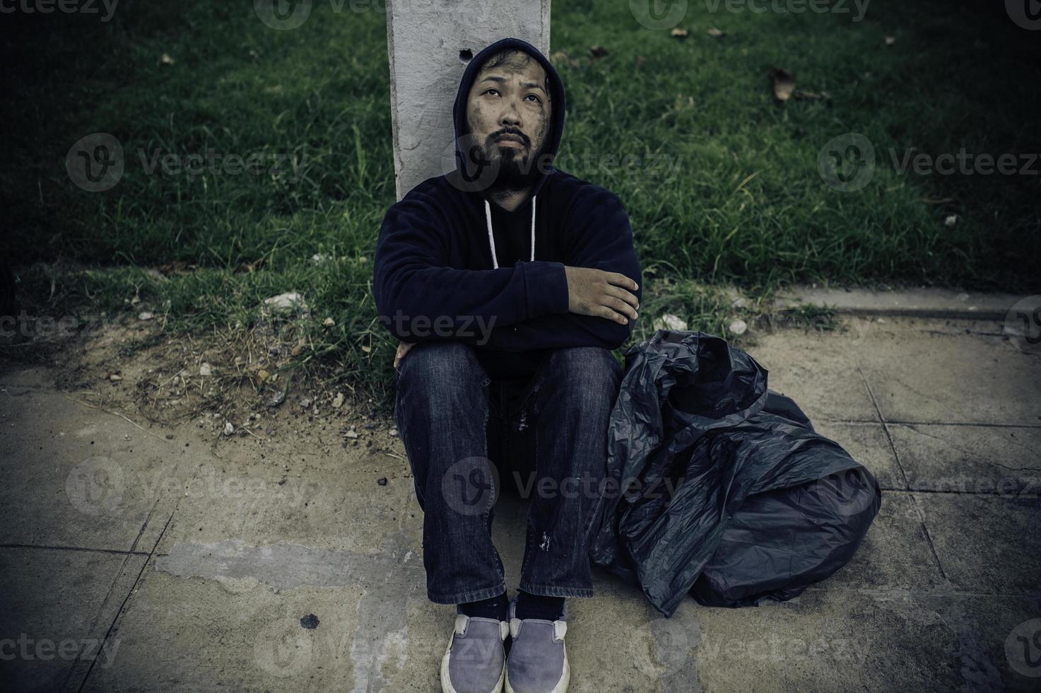 asiatisk man är hemlös på de sida väg, en främling har till leva på de väg ensam eftersom han har Nej familj. foto