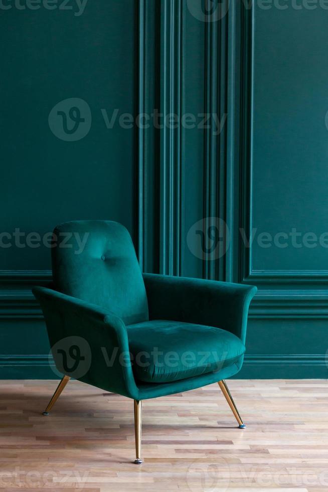 vackert lyxigt klassiskt blågrönt rent inre rum i klassisk stil med grön mjuk fåtölj. vintage antik blågrön stol som står bredvid smaragdväggen. minimalistisk hemdesign. foto