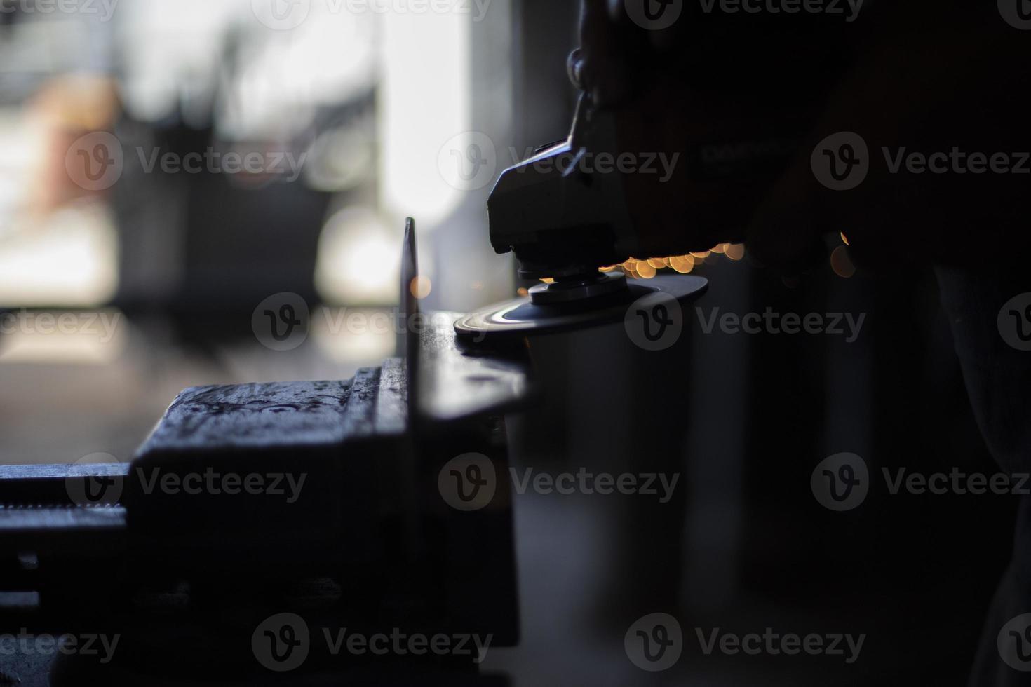 slipning stål. arbetstagare maler metall. arbete i garage. elektrisk verktyg i hand. foto