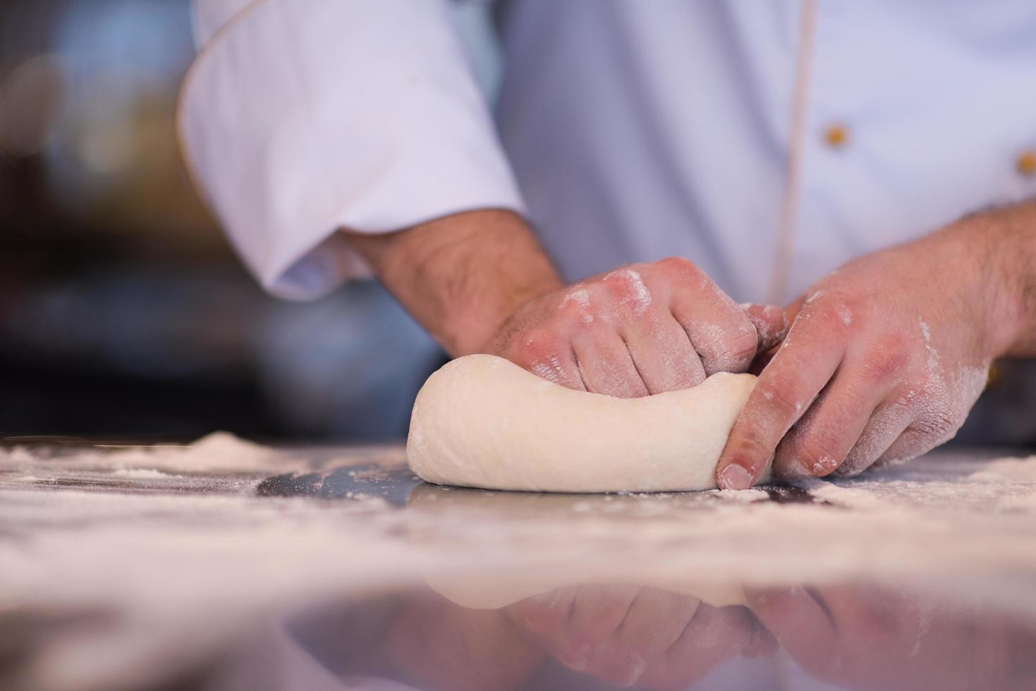 kock händer framställning deg för pizza foto