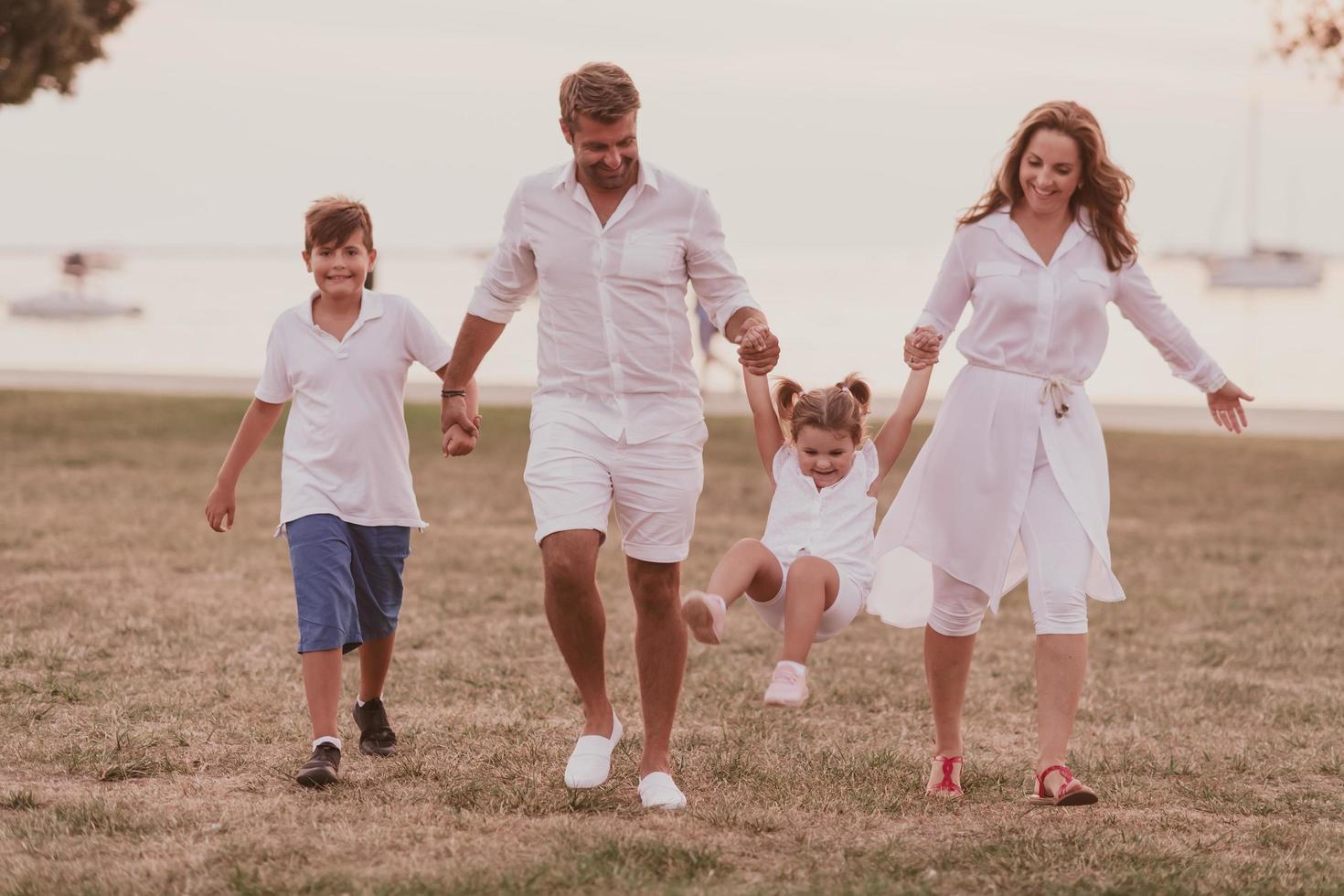 senior par i tillfällig kläder med deras barn, pojke och flicka njut av de strand utgifterna en semester tillsammans. familj tid . selektiv fokus foto