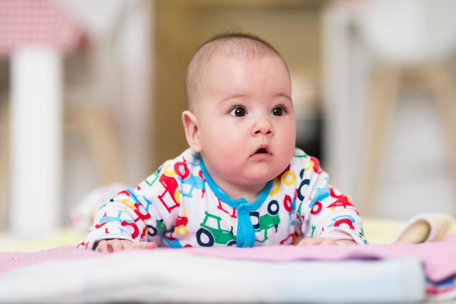 nyfödd bebis pojke spelar på de golv foto