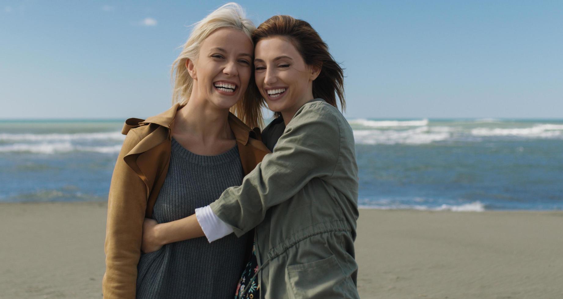 kvinnor leende och njuter liv på strand foto