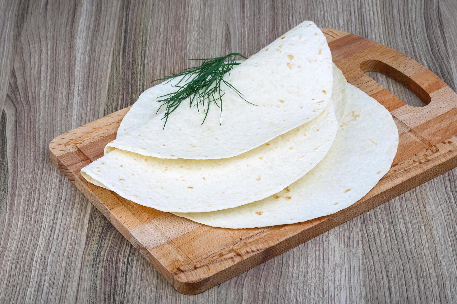 tortillas på trä- styrelse och trä- bakgrund foto