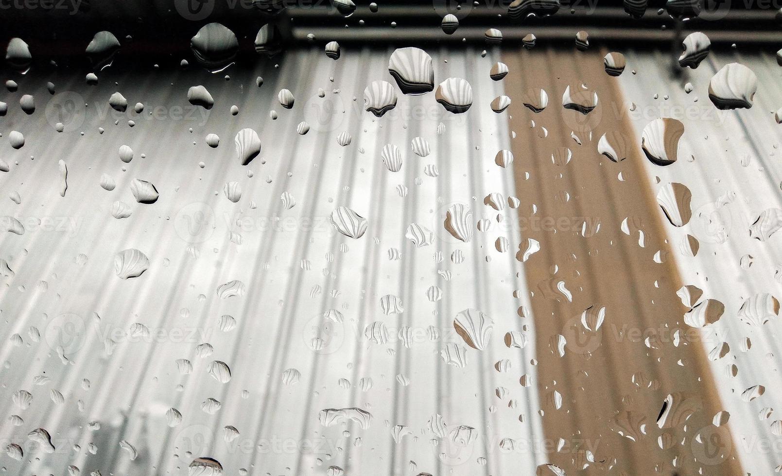 regn droppar i främre av de glas på de silver- tak bakgrund foto