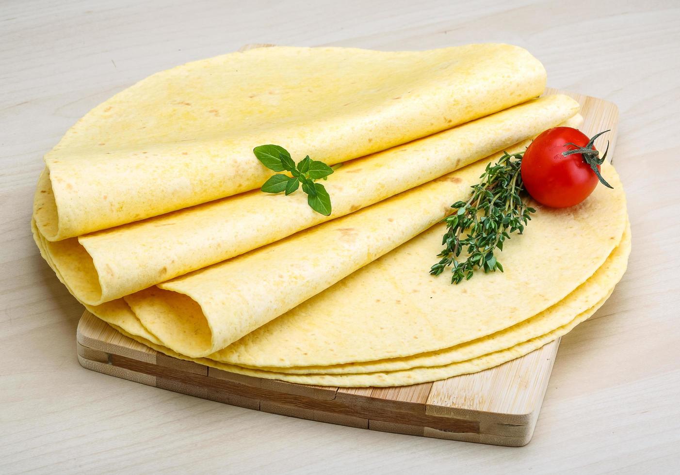 tortilla på trä- styrelse och trä- bakgrund foto