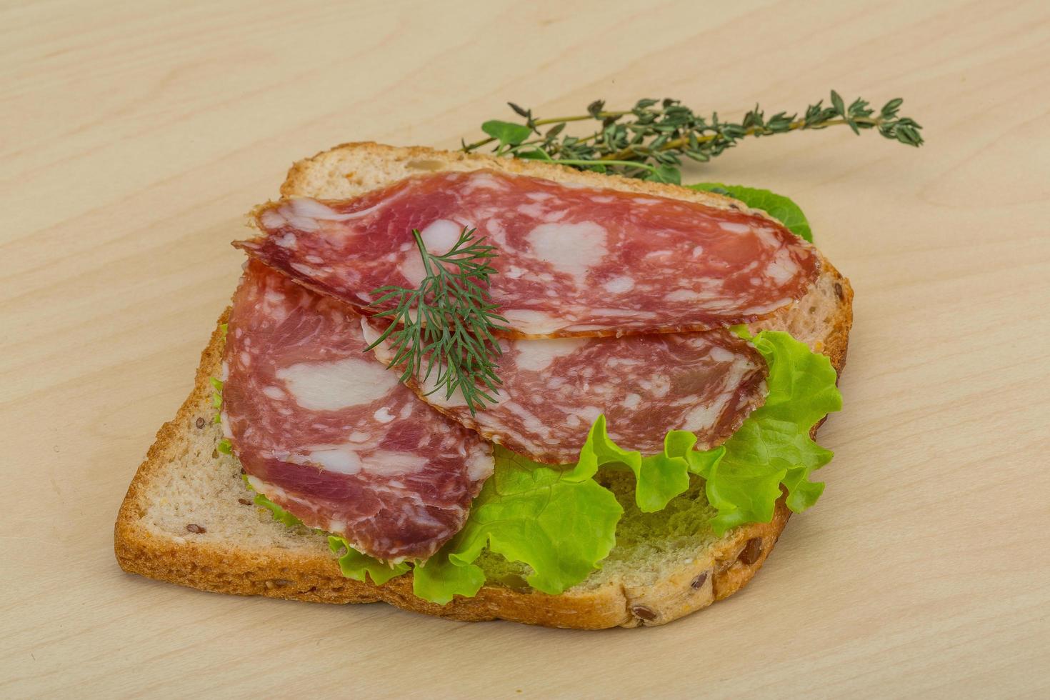 salami smörgås på trä- bakgrund foto
