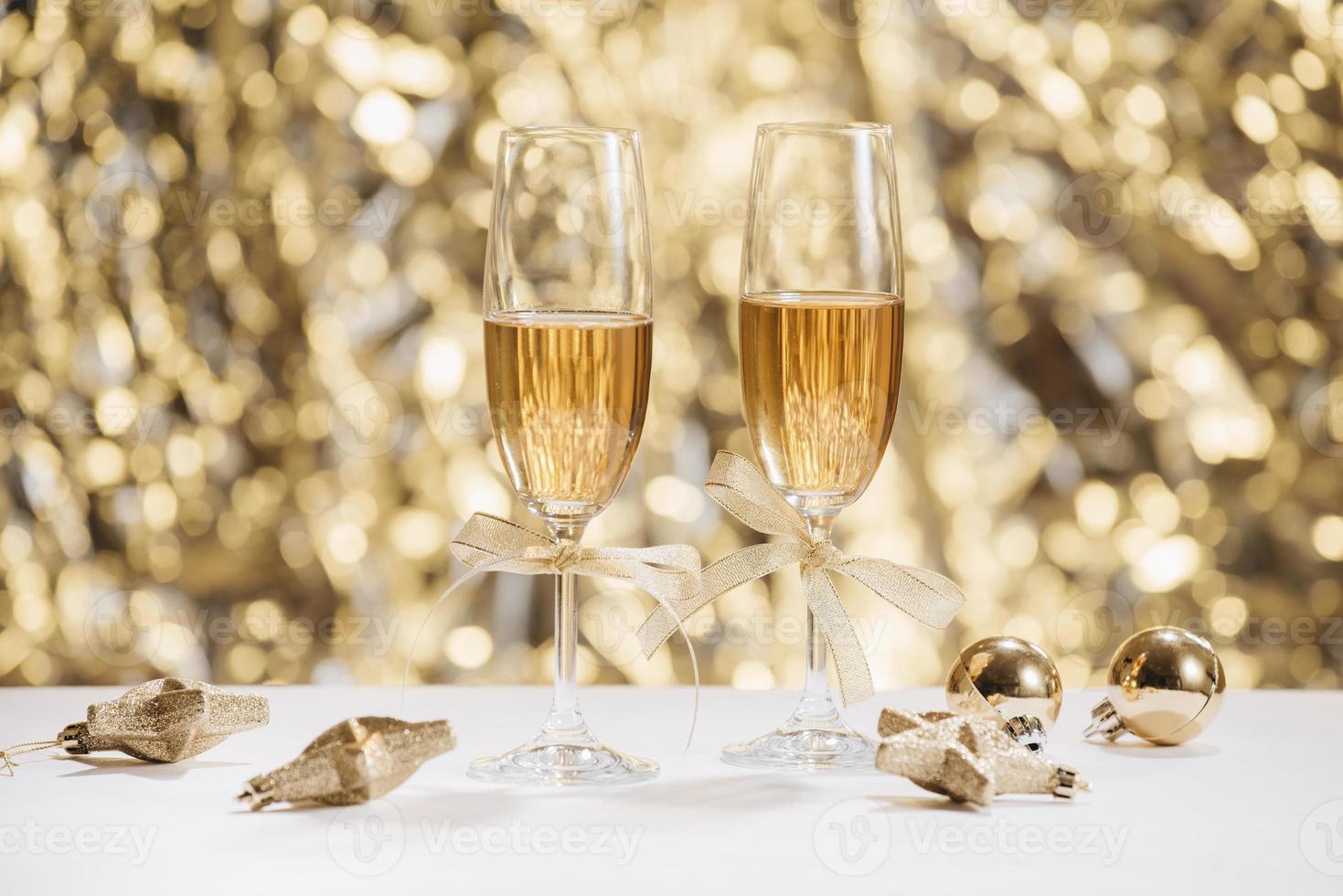 två full champagne glasögon med bokeh lampor i de bakgrund foto