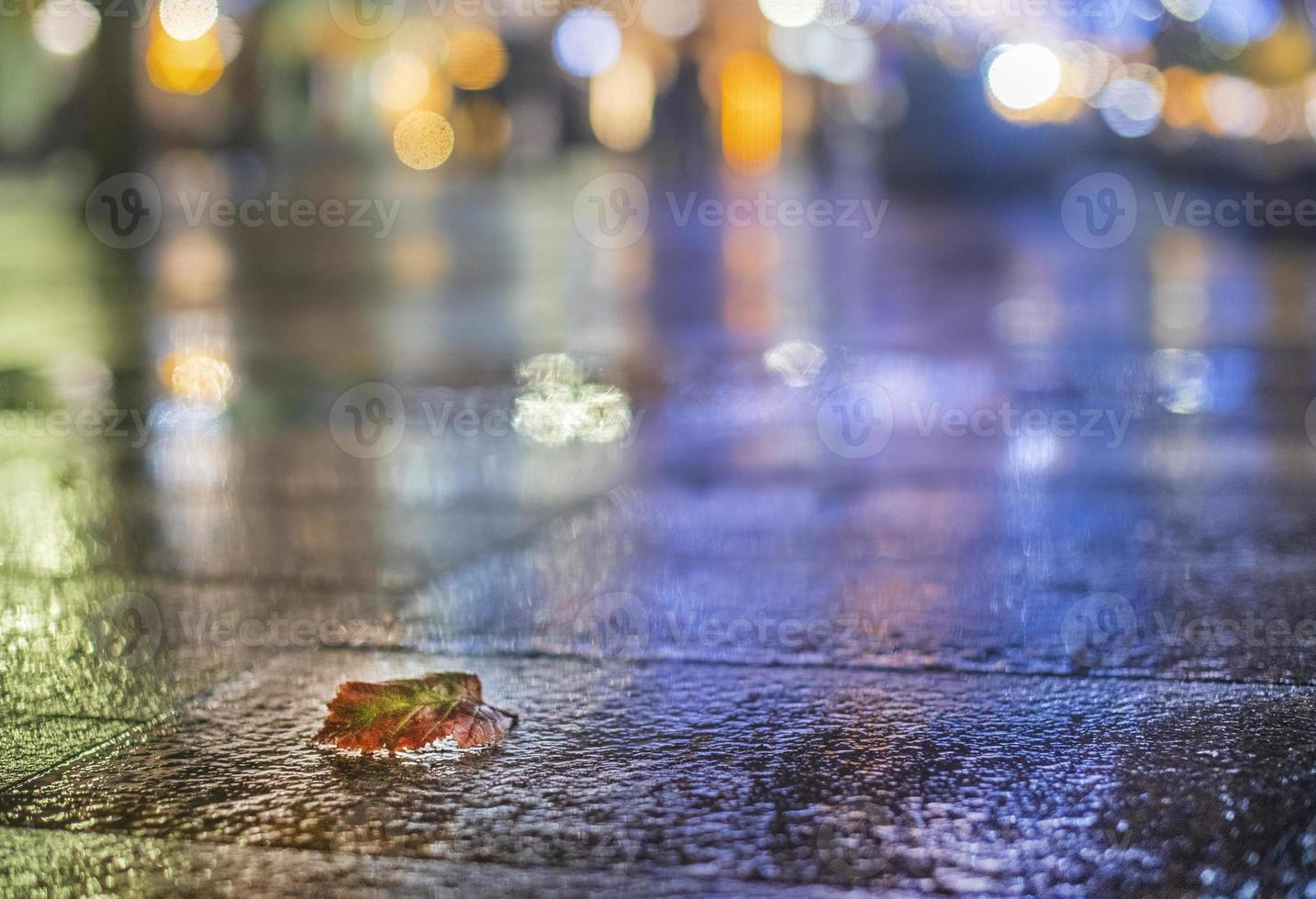 natt urban landskap, färgad lampor reflekterad i de våt asfalt i falla. regnig natt gata i de stad. de lampor av en regnig natt i de höst stad av disfokusera och bokeh. neon gata. foto