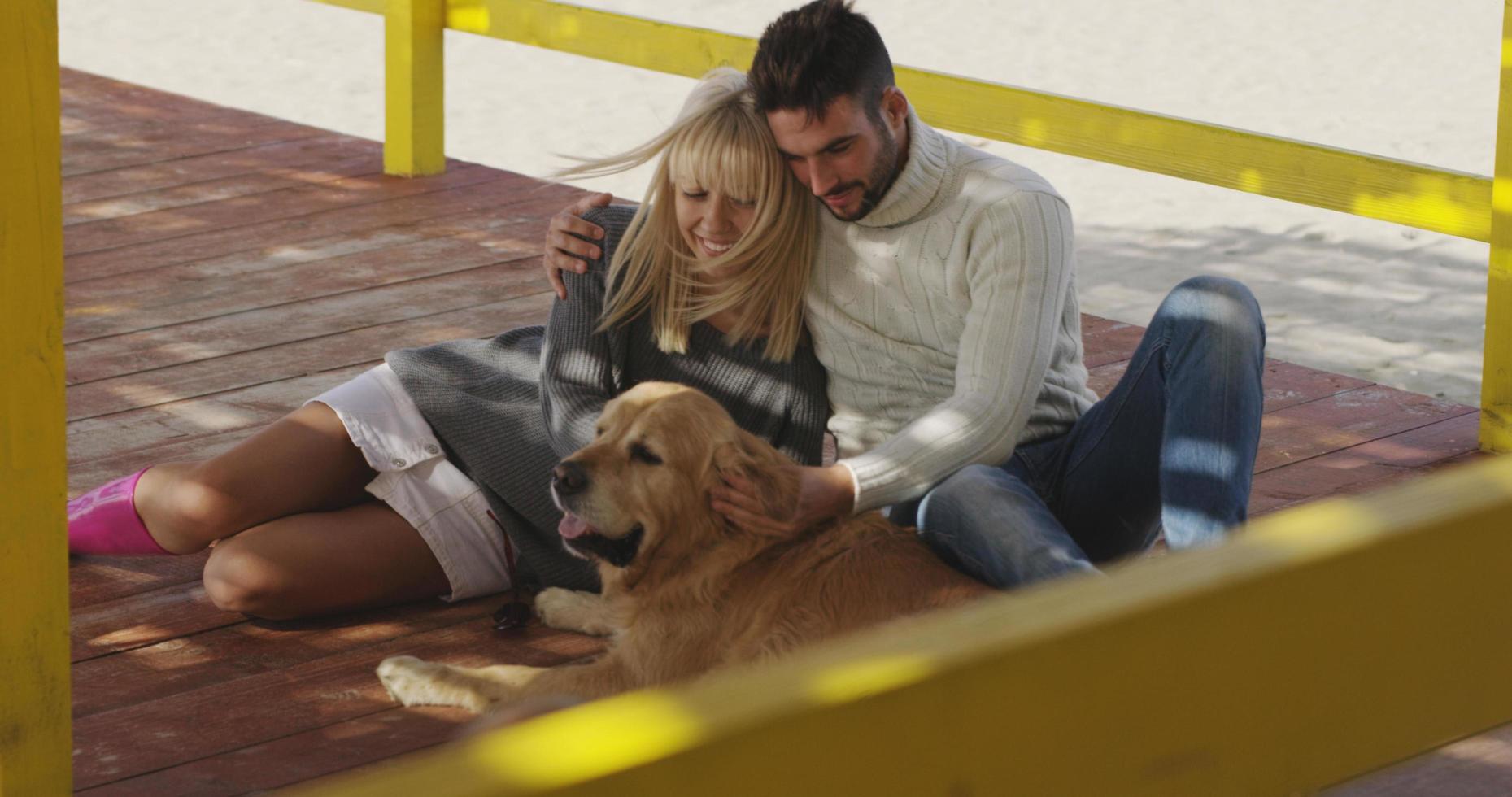 par med hund njuter tid på strand foto