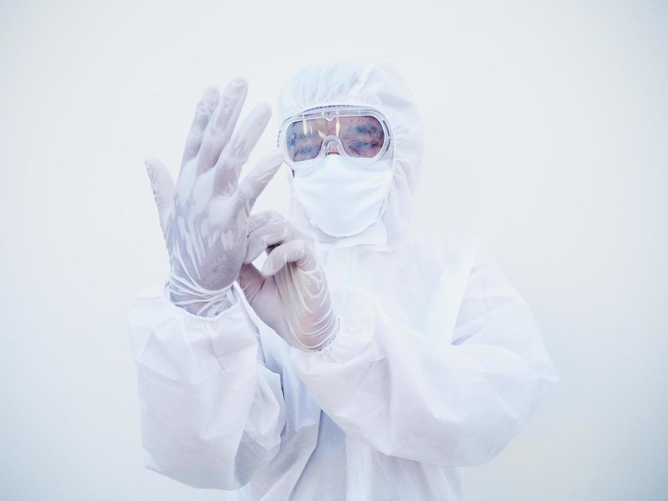 asiatisk läkare eller forskare i ppe svit enhetlig sätta på skyddande vit handskar medan ser händer. covid-19 begrepp isolerat vit bakgrund foto