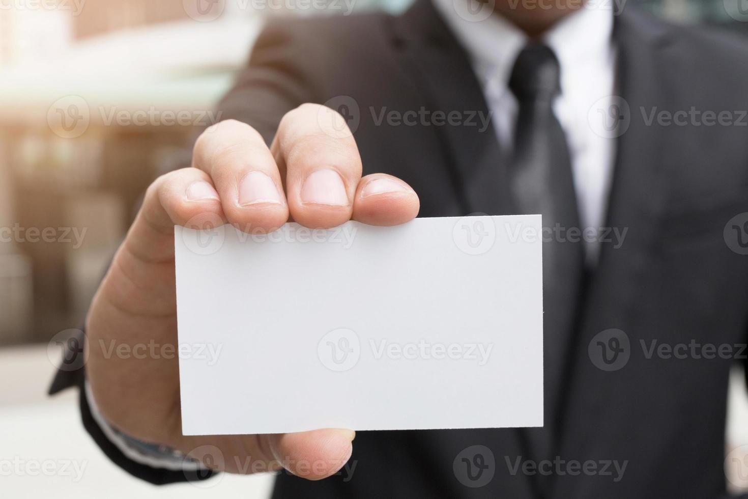 ung affärsman som tar ut tomt visitkort från fickan på sin skjorta kostym, kopiera utrymme foto