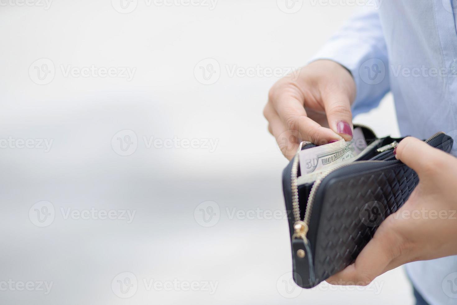 kvinna innehav en mode plånbok, hon är handla på en avdelning Lagra. foto