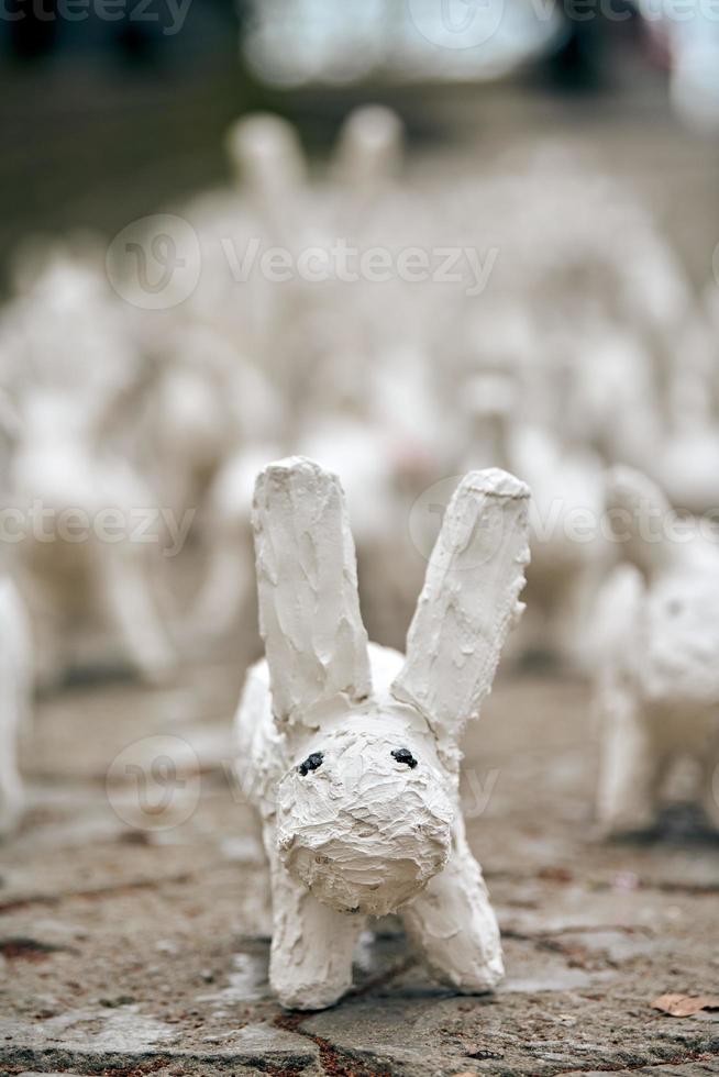 vita kaninstatyer gjorda av gips närbild, konstutställning utomhus, konstgjorda vita harar foto